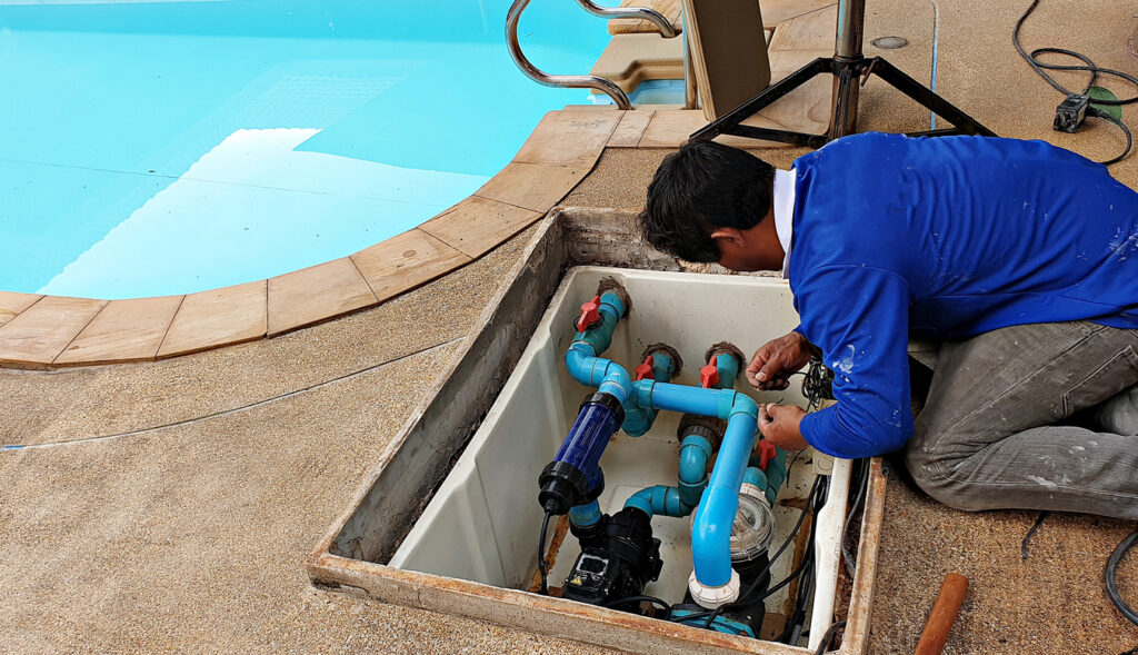 Technician fixing swimming pool water pump. Service and maintenance for swimming pool.